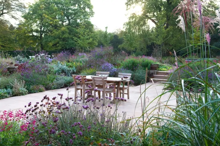 Luxury Surrey garden with outdoor seating, multi-season perennial beds, and subtle architectural features integrating with naturalistic planting design.