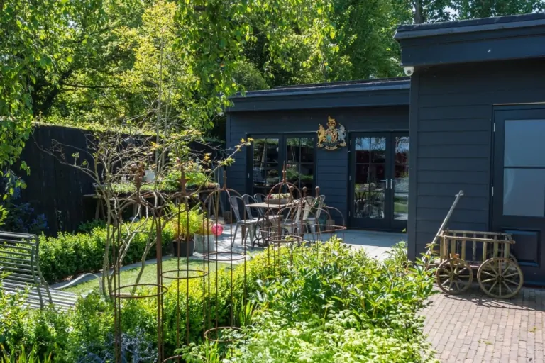 Modern Surrey garden pathway flanked by layered perennial planting and manicured shrubs, highlighting structured and high-end landscape design.