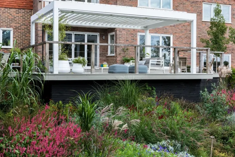 Modern Surrey terrace with layered perennial planting and structured landscaping, illustrating luxury outdoor garden design.