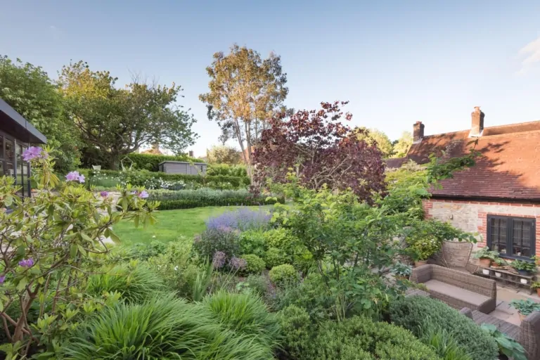 Close-up of layered perennial planting with purple, green, and white foliage, illustrating structured and naturalistic luxury garden design.