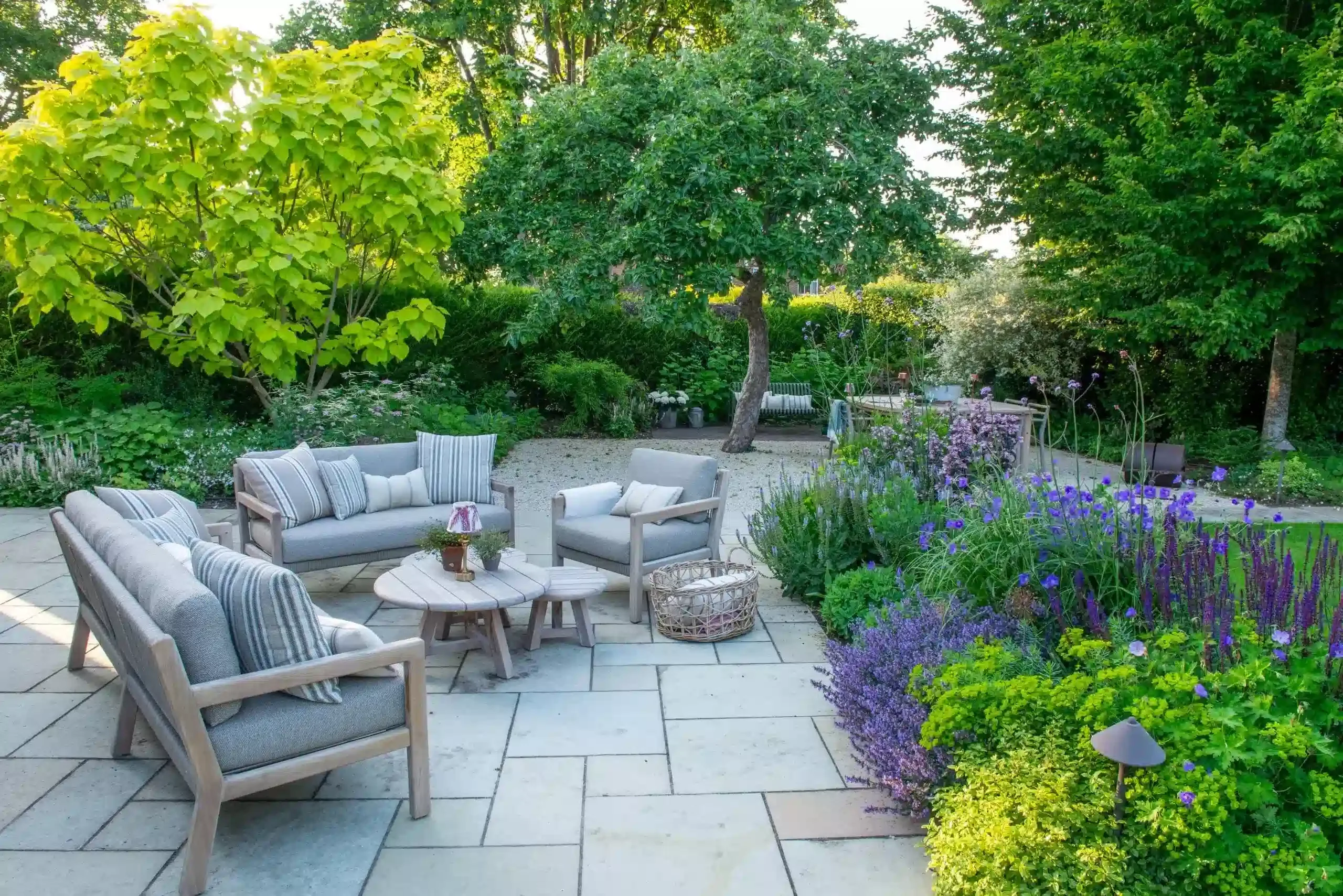Structured perennial beds and manicured lawn in a Surrey garden, highlighting seasonal planting and bespoke landscape design.