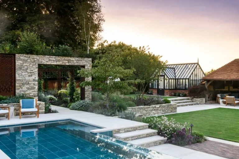 Luxury backyard with swimming pool, stone terrace, and landscaped garden with modern seating and greenery.